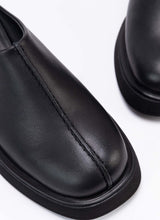 Load image into Gallery viewer, Nahaufnahme der Schuhfront eines coolen Clog-Modells aus schwarzem, zertifiziertem Echtleder. Gut zu sehen ist das Design-Detail, eine raffinierte Wulstnaht, die den Schuhschaft optisch in zwei Seiten unterteilt.