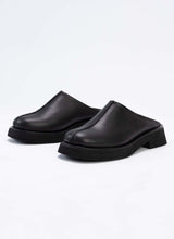 Load image into Gallery viewer, Seitliche Ansicht eines Paares Unisex-Clogs aus traumhaftem Echtleder in zeitlosem Schwarz. Die Schuhe sind mit Modellen von Vagabond vergleichbar. Durch die breite Größenauswahl ist das Modell von Frauen und Männern tragbar. Das Label Cedoublé fertigt ausschließlich in Europa und legt einen Fokus auf nachhaltiges Verhalten in allen Belangen.