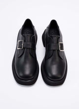 Load image into Gallery viewer, Draufsicht eines Paares Unisex-Halbschuhe aus dem Hause Cedoublé. Die Schuhe sind aus Qualitätsleder in schwarz gefertigt. Dieses Leder ist mit dem Gold-Standard der Leather Working Group ausgezeichnet und weist neben angenehmen Trageeigenschaften auch einen feinen Glanz auf. Über dem Spann des Schuhs befindet sich ein Lederriemen mit einer eckigen, silberfarbenen Schnalle. Die Front der Schuhe ist eckig und leicht abgerundet. Es handelt sich um einen modischen Klassiker.