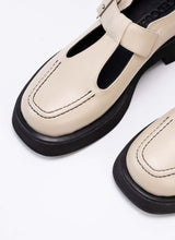 Load image into Gallery viewer, Detailfoto eines cremefarbenen Mary Jane Schuhs aus Echtleder. Als Kontrast wurden schwarzes Lederfutter, eine schwarze Laufsohle und schwarzes Lederfutter verwendet. Die Schuhfront wird von einer Wulstnaht mit schwarzem Stitching geziert.