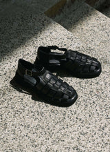 Load image into Gallery viewer, Black leather unisex fisherman sandals with chunky outsole illuminated by the sun