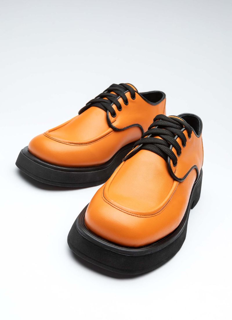 Ein Paar chunky Lederschnürer mit dezenter Plateausohle und Wulstnaht in der Front sowie schwarzer Paspel