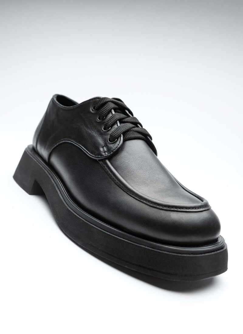Formschöner, klassischer Unisex-Lederschnürer. Vom Obermaterial über die Nähte bis hin zum Futter und zur Sohle ist das Modell einheitlich in schwarz gehalten. Die Sohle verfügt über ein dezentes, modisches Plateau.