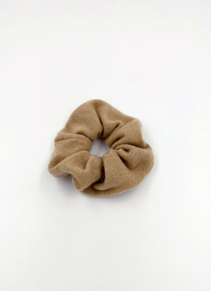 Flauschiges Kaschmir Scrunchie in einem hellen Sandton. Es handelt sich um ein luxuriöses Haaraccessoire.