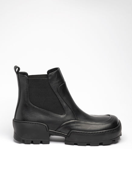 Schwarze Chelsea-Stiefelette aus robustem Glattleder. Es handelt sich um ein sehr modisches Modell in Karreform mit dicker Gummilaufsohle mit Profil.