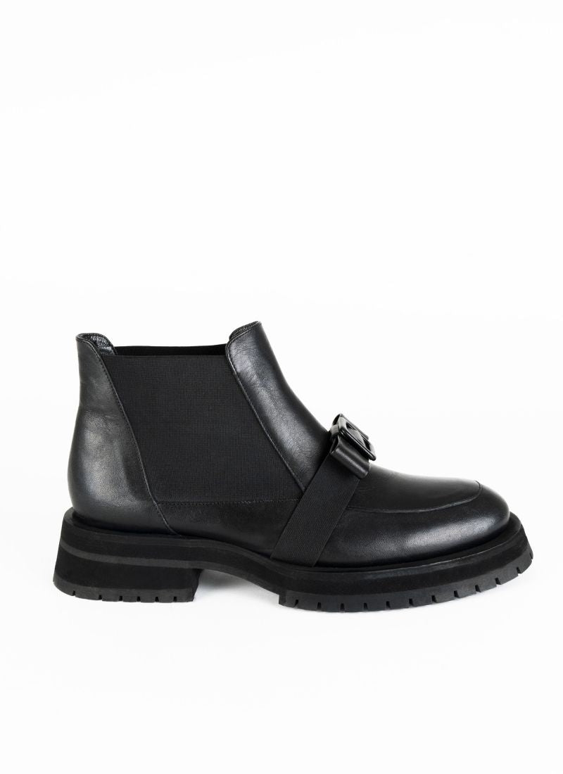 Produktfoto eines schwarzen, knöchelhohen Chelseaboots aus Leder mit dekorativer Schleife über dem Spann. 