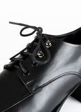 Load image into Gallery viewer, Detailfoto eines schwarzen Schnürschuhs aus Leder mit silberfarbenen Hakenösen.

